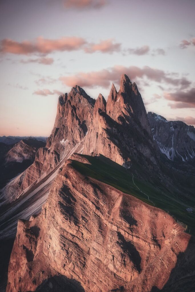 Breathtaking view of the sharp peaks of Seceda in the Dolomites during twilight, highlighting natural beauty.